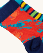 A closer view of the Frugi Rock My Socks 3-Pack - Deep Water. The red socks with blue lobsters and yellow crabs sits in front of the yellow, blue, red and green striped socks.