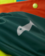 Close up of the reflective fish on the Frugi childrens waterproof beaver print puddle buster