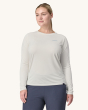 An adult wearing the Patagonia Women's Long-Sleeved Capilene Cool Daily Graphic Shirt in white showing the fit of the top from the front