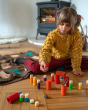 Child sat on the floor playing with the Grapat rainbow Lo stacking tubes 