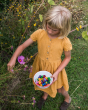 Girl picking flowers and holding a bowl of Grapat wooden mandala mushrooms