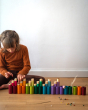 Child sat on the floor playing with the Grapat plastic-free stacking wooden La toy set