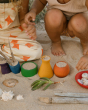 Children have filled the Grapat Wooden Rainbow Sorting Pots with sand and various items found on the beach
