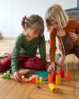 Two children playing with the Grapat plastic-free wooden lo tube set on a wooden floor