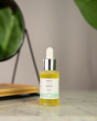 Green People Anti-Ageing Facial Oil with Sequoia and Rosehip in a dropper bottle, pictured in front of a mirror on a marble sideboard
