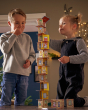 Two children stacking the HABA Rhino Hero Card Stacking Game cards together