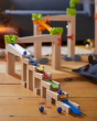 A closer view of the HABA Wooden Melodious Marble Run showing the blocks, musical blocks and marbles set up on a wooden floor