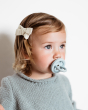 Close up of young girl with a Hevea blue natural rubber pacifier in her mouth