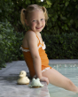 Hevea Upcycled rubber sand duck and sage frog toys on the poolside next to a small child