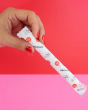 hey Girls Regular Absorbency Cardboard Applicator Tampons. Image shows a person with red nail varnish holding a tampon in its packet, in their hand on a red and pink background