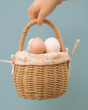 The Olli Ella Rattan Berry Basket with Lining – Gumdrop. A beautiful lined rattan basket, with gumdrop print on a blue background. Inside the basket are colourful eggs