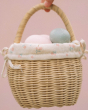 A closer look at the Olli Ella Rattan Berry Basket with Lining – Pansy Floral. A beautifully woven rattan basket with cream cotton lining with a vintage pansy floral pattern, on a pink background. Inside the basket is colourful pink and blue eggs