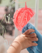 Close up of hand wiping some red Kitpas non-toxic crayon off of a window