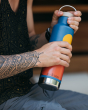 A person holding the Klean Kanteen 20oz / 592ml Insulated Classic Loop Cap Bottle - Mountains in their hand