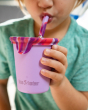 Close up of a child drinking from a Klean Kanteen steel drinks cup with a tie dye coloured straw