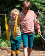 Two children playing together outside in the sun. The child in front is wearing a striped long sleeve top and the Little Green Radicals Blue Marl Comfy Jogger Shorts. Made from GOTS organic cotton, they comfy blue shorts have two pockets and an orange dra