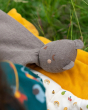 A closer view of the Little Green Radicals Bear Organic Cotton Soft Toy, on a yellow blanket and a grassy background