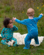 Two toddlers on a fluffy blanket. The toddler on the right is wearing the Little Green Radicals Dawn Organic Cotton Zip Babygrow, and the child on the left is wearing the  Little Green Radicals Garden birds Cotton Zip Babygrow