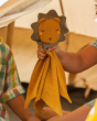 A child holding the Little Green Radicals Lion Organic Cotton Soft Toy whilst at inside a tent