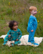 Two toddlers on a fluffy blanket. The toddler on the right is wearing the Little Green Radicals Dawn Organic Cotton Zip Babygrow, and the child on the left is wearing the  Little Green Radicals Garden birds Cotton Zip Babygrow