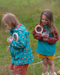 Two children happily exploring with their glass jars and magnifying glasses. The child on the left is wearing the Little Green Radicals Garden Birds Recycled Waterproof Windbreaker Jacket and the child on the right is wearing the Little Green Radicals Tea