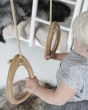 Close up of a childs hands holding the Lillagunga oak wood rings set in a bright play room