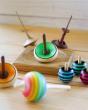 Mader plastic-free Zwirbel wooden spinning top on a Mader mini spinning plate next to some other wooden spinning toys