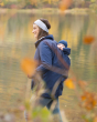Woman walking in front of a lake wearing the Mamalila allweather baby wearing jacket with a baby on her back
