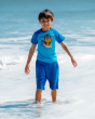 A child happily playing in the sea, wearing Maxomorra muslin blue shorts, and the Maxomorra Children's Organic Cotton Monkey Raglan Short Sleeve Top