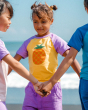 A child playing on a beach with their friends, wearing the Maxomorra Children's Organic Cotton Pineapple Raglan Short Sleeve Top and purple shorts