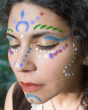 Close up of a woman's face decorated with colourful Natural Earth face paints