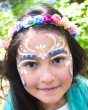 Close up of a young girls face, decorated with blue, white and orange Natural Earth eco-friendly face paints