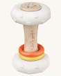 A closer look at the Sophie The Giraffe So Pure Totum Rattle, showing the natural wood grain, the rubber ends and yellow and orange ring, on a cream background