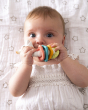 A child happily chewing on the Sophie la Girafe® - So'Pure Multi-textured Sensory Teether Ring