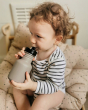 Child holding the One Green Bottle 350ml plastic free tough water bottle sat on a brown cushion