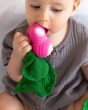 Close up of a young child holding the Oli & Carol Ramona radish doudou baby toy up to it's mouth