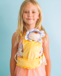 A child carrying Lavender Pickle in a Yellow Buttercup Carrier, on a blue background 