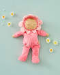 Olli Ella Dozy Dinkum Doll - Fucshia Twinkle in a soft velvet petal pink onsie, sleepy eyes and a brown tuft of hair, on a light green background surrounded by dasies
