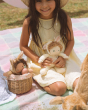 A child smiling and playing with the Olli Ella Dinky Dinkum Doll Fluffles - Babbit Bunny