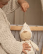 A child pulls out the pompom of Lyra Lullaby Dinkum Doll to play a soothing melody. 