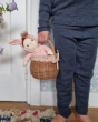 A child holding the Olli Ella Rattan Berry Basket with Lining – Gumdrop. Inside the basket is a Dinkum doll with a pink onsie