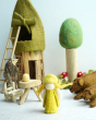 Close up of a Papoose bright felt elf toy on a white background next to some Papoose woodland chairs and animal figures