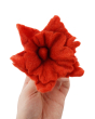 Close up of a hand holding a Papoose plastic-free soft felt flower toy on a white background