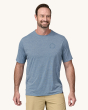 An adult wearing a Patagonia Men's Capilene Cool Daily Graphic Shirt in grey, showing the fit on the front of the t-shirt