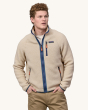 An adult wearing the Patagonia Men's Retro Pile Jacket - Dark Natural / Utility Blue, with a Patagonia logo on the chest, navy blue zipper and zip, and brown zipper pulls.