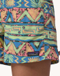 A close up of the Patagonia Women's Baggies Shorts - High Hopes Geo / Salamander Green showing water drops on the fabric, on a cream background