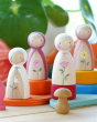 Peepul plastic-free wooden peg dolls stood on some wooden blocks in a line next to some Moon Picnic mushrooms