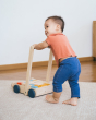 Young toddler walking around holding the Plan Toys eco-friendly wooden baby walker