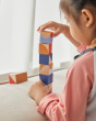 Close up of young girl stacking up the PlanToys childrens plastic-free geo blocks on a white window sill