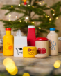 Close up of the PlanToys plastic-free wooden food and beverage play set in front of a small Christmas tree